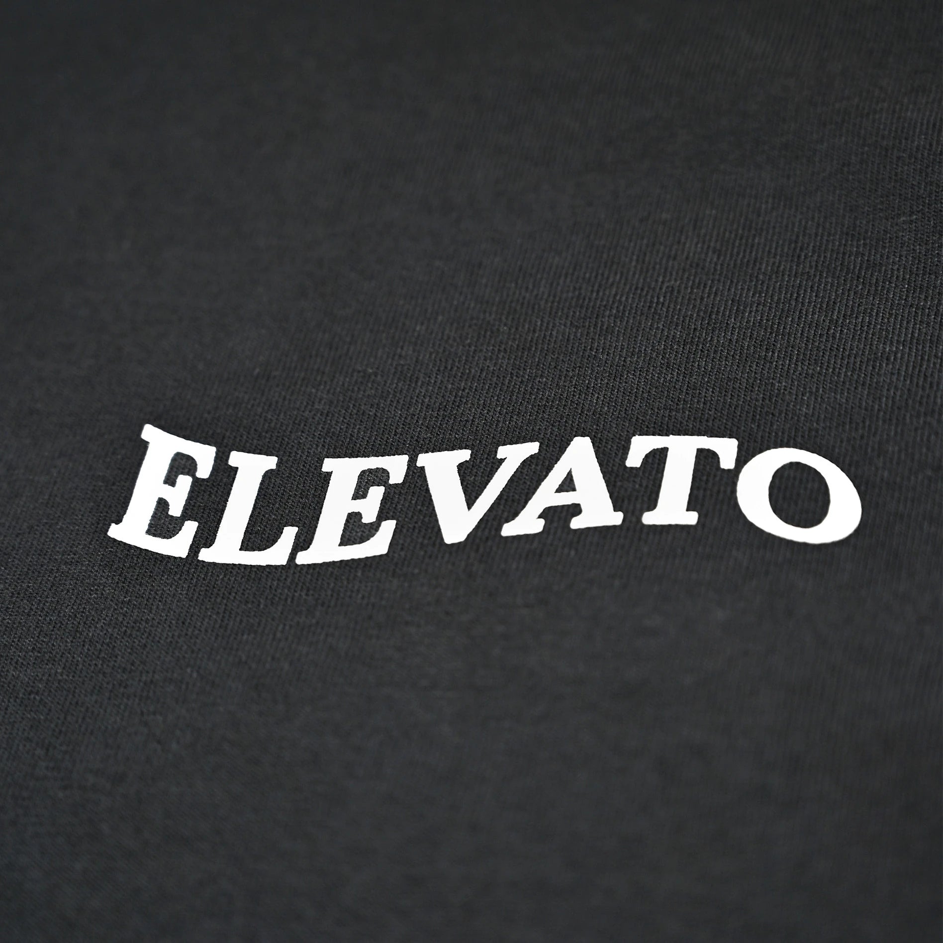 A black tee with a wavy Elevato logo on its left chest