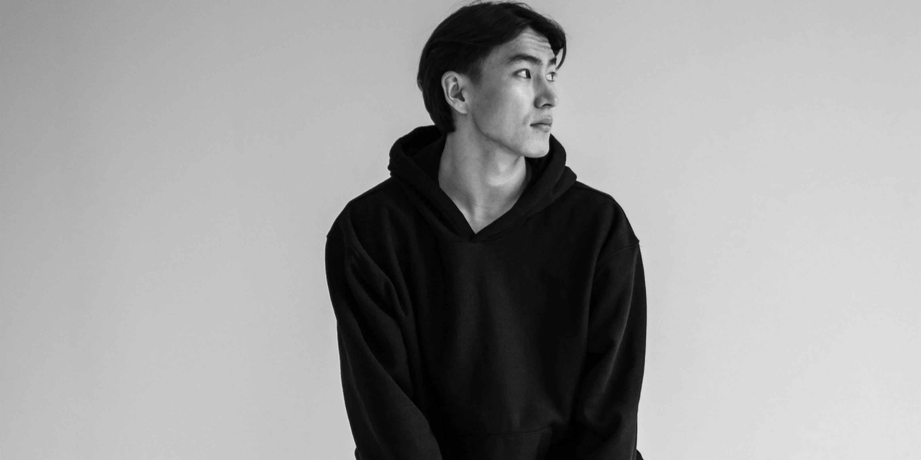 A man wearing a black hoodie looking to the left